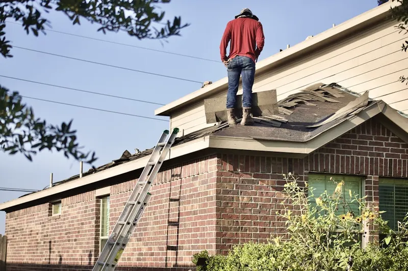 Professional roofer working on a residential roof in Sibley Forest